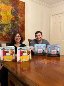 Lynn and Jon Greenberg pose with their Creative Cab Company children’s books in English and Spanish.