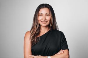Headshot of Diana Vasquez, founder and president of Casa Chapulina, wearing a black top against a light gray background.