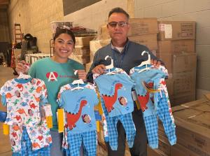 Carlos Lopez of FACE posing with Alyssa Argomaniz of ArrowHeart while receiving FACE's clothing donation.