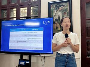 Mme Huyen tient un micro devant un écran présentant le tourisme durable et le logo Lux Travel DMC.