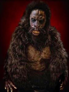 Sasquatch costume with brown fur and a snarling face against a red background.