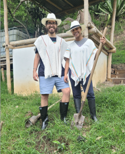 The Fruition Coffee Team stands smiling next to their freshly planted coffee bean seedling in Columbia.