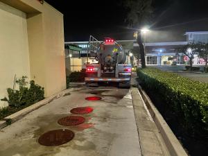 A technician performs grease interceptor service at a commercial restaurant in Orange County.