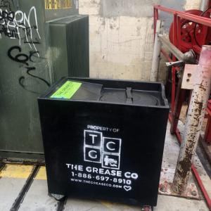 A dedicated container provides a secure collection point for used cooking oil and waste grease from restaurant kitchens.