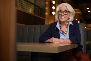Judy K. Herman smiling while seated at a table in a professional setting.