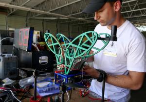For test flights, a Chargebotic engineer builds the clamping system for a parasitic, energy harvesting UAV from 3D-printed parts made on the spot at JIFX.