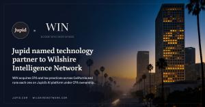 Jupid and WIN logos over a view of Wilshire Boulevard in Los Angeles at dusk