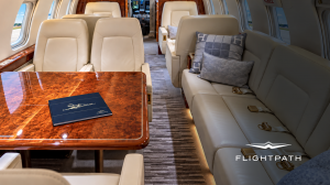 Flightpath Jet Guide displayed on a table inside a Challenger 605 private jet.