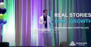 Trevor Rappleye speaking on stage with the words Real Stories, Real Growth.