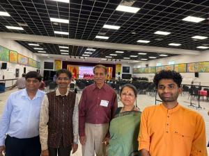 Five participants standing inside the HMEC 2025 conference venue at DFW Hindu Temple in Irving, Texas.