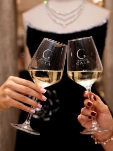 Two guests toast with Maison Cala branded rosé glasses during the Monaco pre-launch event.