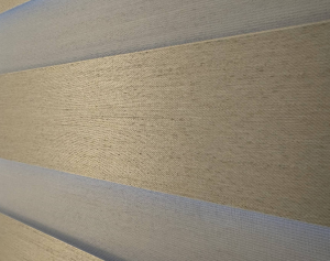Macro view of premium textured fabric weave alternating with sheer horizontal stripes on a custom window shade.
