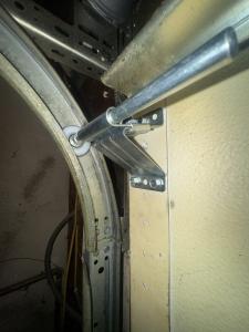 Heavy-duty sealed nylon ball-bearing garage door rollers installed in steel tracks during a roller replacement in California.