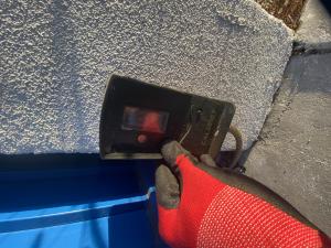 Close-up of optical safety sensors being aligned and tested along vertical garage door tracks in Pasadena, California.