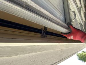 Professional technician installing a replacement high-cycle garage door spring during an emergency service visit in Pasadena, California.