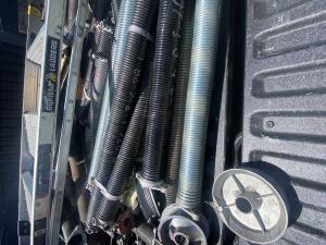 Comparison display of heavy-duty commercial-grade torsion and extension spring replacement options by a local garage door company in Santa Clarita, California.