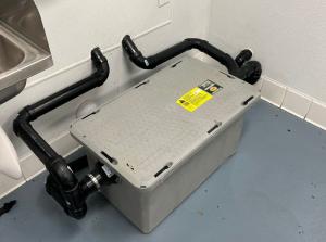 Grease trap beneath a restaurant kitchen sink in Riverside