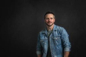 Drew Lachey in front of dark background