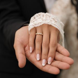 Woman wearing a gold moissanite ring during a wedding