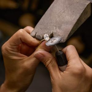 Jeweler polishing a moissanite ring during the jewelry making process