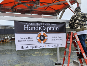 HandiCaptain accessible boat boarding station at Caseville Municipal Harbor featuring branded signage produced by Feury Image Group.