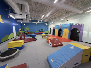 Interior of the newly opened Romp n’ Roll Gilbert in Arizona, featuring a colorful indoor play gym with slides, climbing structures, gymnastics mats, trampolines and imaginative play areas.
