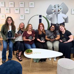 Quarter 2 Award recipients sitting on a couch with awards in hand.