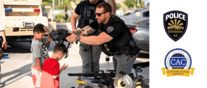 Police officer shows two children a tactical robot, with Goodyear Police and Certified Autism Center logos.