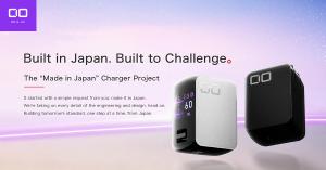 Two CIO NovaPort III wall chargers, one white and one black, floating against a soft purple and pink gradient. The silver charger’s screen shows output for ports C1 and C2 at 60W. Headline text reads “Built in Japan. Built to Challenge.” above “The Made 