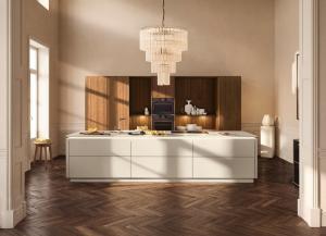 Walnut Rosado tall cabinets behind a white handleless island under a chandelier, Nolte neoFLAT Walnut Rosado, Aksesuar Design