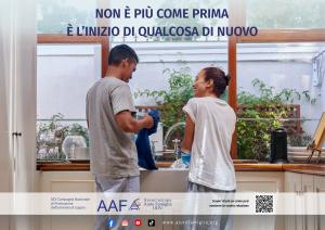 Una coppia sorride mentre lava e asciuga i piatti in cucina. Locandina della XIX Campagna Nazionale per l’armonia di coppia di AAF – Associazione Aiuto Famiglia ODV, con il messaggio “Non è più come prima. È l’inizio di qualcosa di nuovo.”