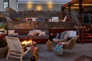 Outdoor patio with comfortable seating, blankets, and a fire pit.