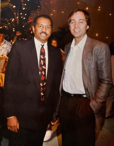 Mac McGill standing with Former President of NBC Brandon Tartikoff at a holiday party