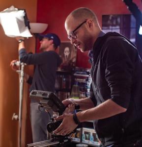 Director Bradley Elliot Norton blocking a scene with camera in-hand.