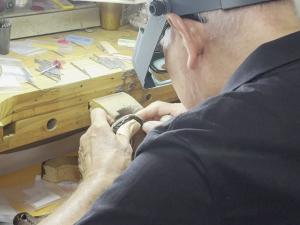 Guru Diam bench jeweler setting a custom diamond jewelry piece in the workshop