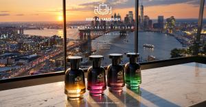 Four Reeh Al Madinah Nasmah perfume bottles on a marble surface overlooking the New York City skyline at sunset.
