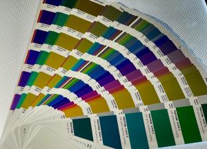 Pantone color guide with numbered swatches fanned across a perforated tabletop.