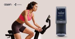 Agen x CAROL logo lockup above a woman wearing headphones riding a CAROL exercise bike, beside an Agen Robot dispenser whose screen reads “Your energy boost formula is ready”