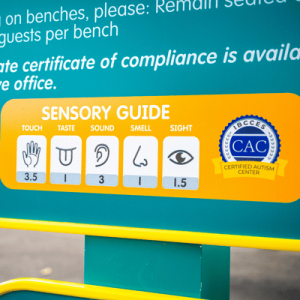 Sign displaying a sensory guide with touch, taste, sound, smell, and sight ratings, plus a Certified Autism Center badge.