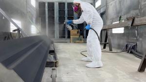 AEGIS Advanced technician in protective suit spray applying an industrial coating