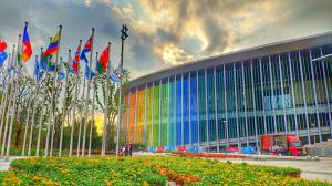 Rows of international flags beside the glass facade of the National Exhibition and Convention Center in Shanghai.