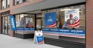 Campaign office storefront with window graphics, a feather flag, and an A-frame sign.