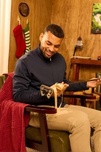 A man smiles as he opens golf themed presents including a new putter.