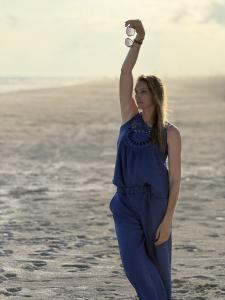 woman on beach in old greek town using laptop