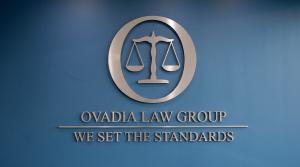 Ovadia Law Group metal sign on a blue wall