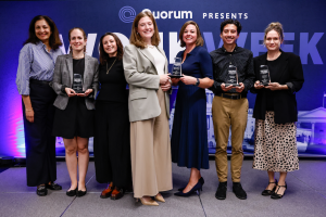 Seven people on stage at Quorum’s Wonk Week, four holding 2026 Wonk Awards trophies, in front of a purple Capitol backdrop.