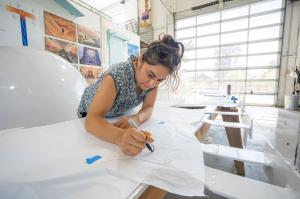 Erika Huether cuts stencils to match the original di Rosa sheep design at Gordon Huether’s Napa studio. (Photo by Michael Cuffe)