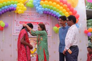 A woman receiving a medal at a community event associated with Sakar Trust's rural blood donation initiatives in South Gujarat.