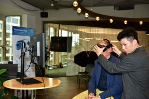 Neurobit CTO conducting a live demonstration of the NeuroSwift Pro infrared camera headset, showing a non-invasive neuro-ocular patient assessment during the Rotterdam launch.