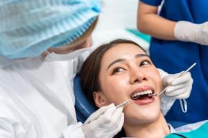 Woman receiving a thorough dental examination from dentists during a routine oral health checkup